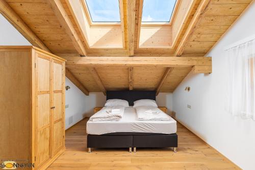 a bed in a room with a wooden ceiling at Sonnrain GmbH Apartment Sonnberg 77 Leogang in Leogang