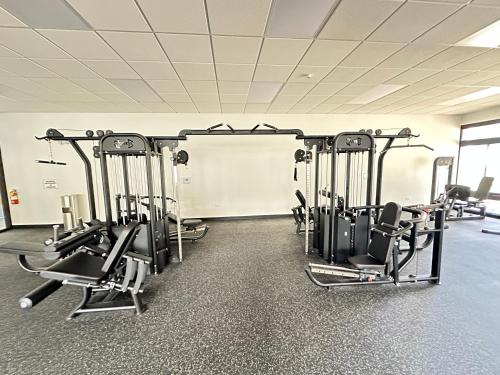 a gym with several tread machines in a room at New 4 Bedroom Home with Ocean and Gorgeous Mountain Views in the gated community of Mauna Olu in Waianae