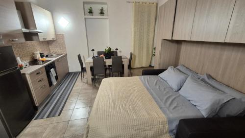 a bedroom with a bed and a kitchen with a table at Corte Malpensa in Somma Lombardo