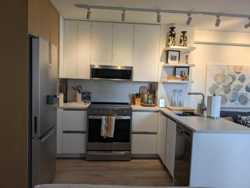 a kitchen with white cabinets and a stove top oven at Executive Studio in Vancouver