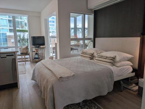 a bedroom with a large bed and a television at Executive Studio in Vancouver
