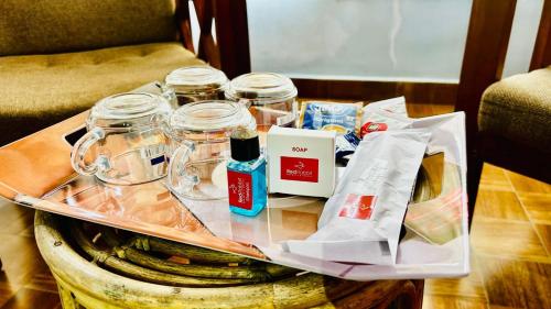 a table with a tray with glass jars on it at Vaga Hills Resort by Red Rabbit in Vagamon