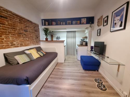 une chambre avec un lit et un mur de briques dans l'établissement La Maison de Maila, à Toulouse