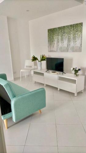 a living room with a couch and a tv at Casa Plumeria in Marinella di Selinunte
