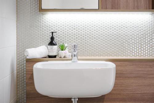 a bathroom with a white sink and a bottle of wine at Waterloo 1Br town close to Train Shopping in Sydney