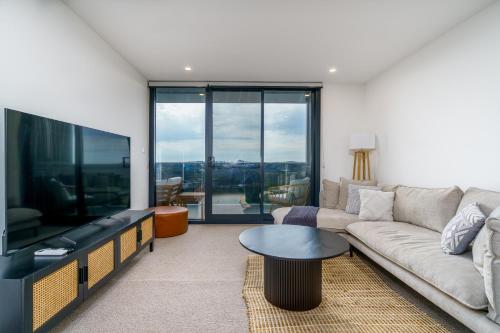 a living room with a couch and a flat screen tv at Urban Apt in Phillip 9mins to Canberra Hospital - Hosted by Canstay in Phillip