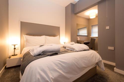 sypialnia z dużym łóżkiem z dwoma ręcznikami w obiekcie Aaron Wise Apartments w Cardiff