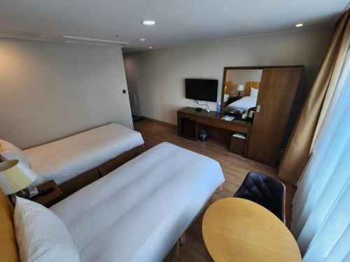 a hotel room with a bed and a mirror at Hotel Haema in Jeju