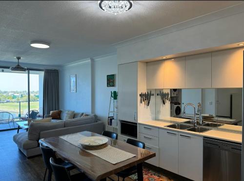 a kitchen and living room with a table and a couch at Harbour Quays Apartments in Gold Coast