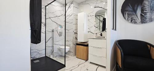 une salle de bain avec toilettes et douche en verre dans l'établissement L'exquis 800m plage et croisette, à Cannes