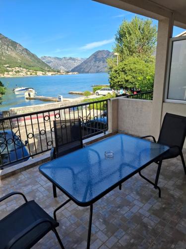 a table and chairs on a balcony with a view of the water at Apartments Pejanović in Kotor