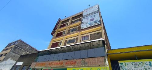 a tall yellow building with a billboard on it at Antonio Accommodation Nakuru in Nakuru