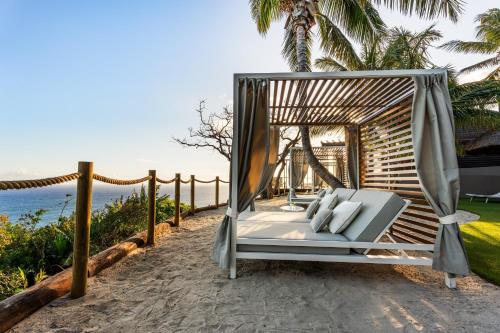 a swinging bed on a beach near the ocean at Palm Hotel & Spa in Petite Île