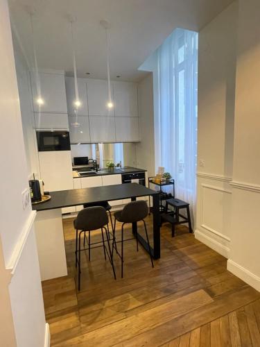 une cuisine avec une table et des chaises dans une pièce dans l'établissement Appartement de charme Art Déco - Hyper-centre ville - Place d'Erlon - Gare - Reims, à Reims