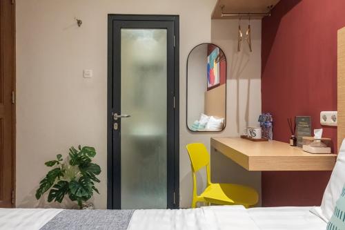 a bedroom with a bed and a desk and a mirror at Mono Coliving Pakis, Surabaya in Wonokitri 2