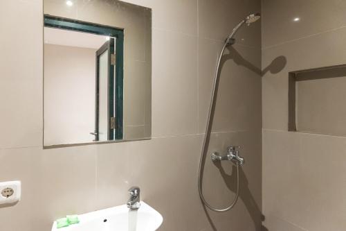 a bathroom with a shower and a sink and a mirror at Mono Coliving Pakis, Surabaya in Wonokitri 2