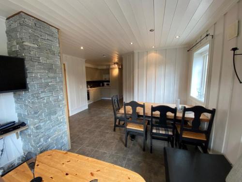 a dining room with a table and chairs and a stone wall at Ruud Tun in Hafjell