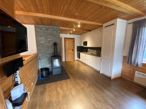 a living room with a television and a kitchen at Ruud Tun in Hafjell