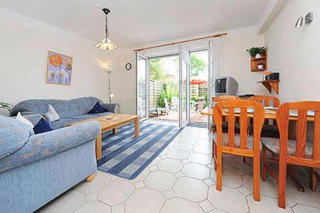 ein Wohnzimmer mit einer Couch und einem Tisch in der Unterkunft Ferienwohnungen Haus Taddigshus in Bensersiel
