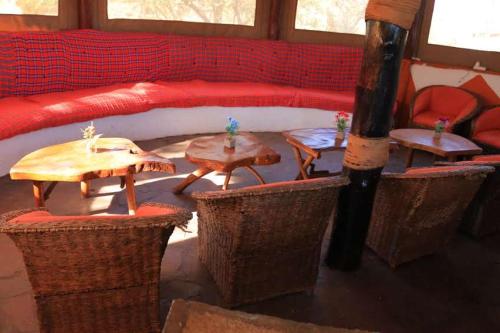 a living room with tables and a red couch at ELANGATA OLERAI LUXURY TENTED CAMP in Narok