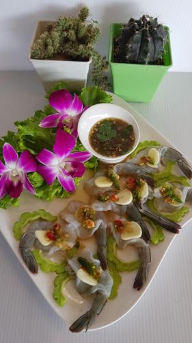 a plate of food with mushrooms and a bowl of soup at Kasithorn Apartment's & Hotel in Phetchabun