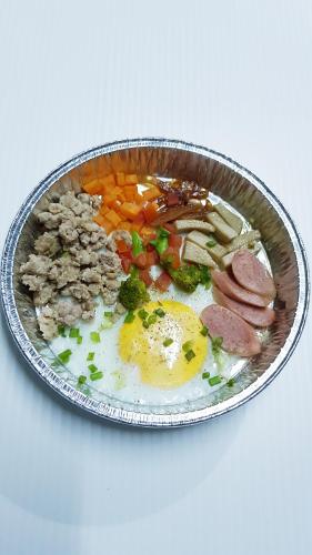 a tin bowl of food with eggs meat and vegetables at Kasithorn Apartment's & Hotel in Phetchabun