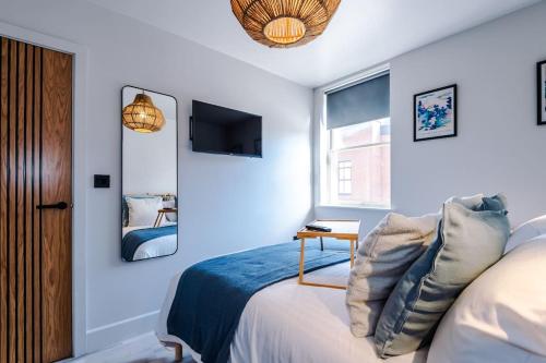 a bedroom with a bed and a tv on the wall at Elegant 2B Retreat City Centre with Secure Parking in Chester