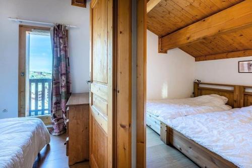 une chambre avec deux lits et une grande fenêtre dans l'établissement Résidence Les Alpages - CHALET DES ALPAGES N°19 MAE-5781, à La Plagne Tarentaise