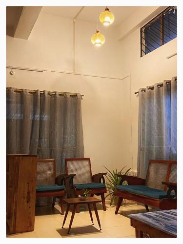 a room with chairs and tables and curtains at Zion Backpackers Hostel in Guwahati