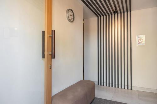 a room with a couch and a clock on the wall at Mono Coliving Pakis, Surabaya in Wonokitri 2
