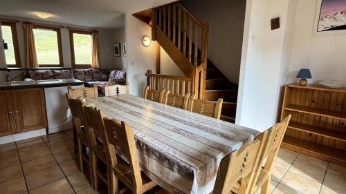 une cuisine et une salle à manger avec une table et des chaises en bois dans l'établissement Résidence Les Alpages - Chalet des ALPAGES N°28 MAE-4711, à La Plagne Tarentaise