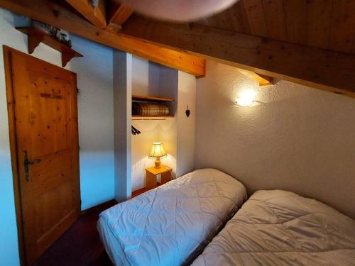 - une chambre avec un lit, une porte et une lampe dans l'établissement Résidence Les Alpages - Chalet des ALPAGES N°28 MAE-4711, à La Plagne Tarentaise
