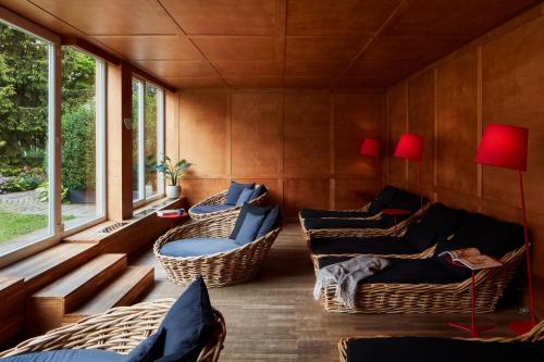 a room with wicker chairs and tables and windows at Falkensteiner Spa Resort Marianske Lazne in Mariánské Lázně