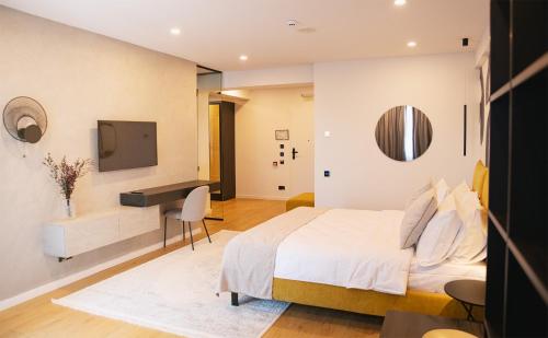 a bedroom with a bed and a desk and a television at Electra Aparthotel in Rădăuţi