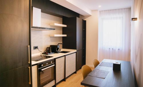 a small kitchen with a table and a dining room at Electra Aparthotel in Rădăuţi