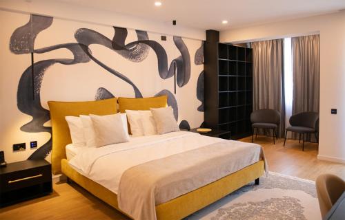 a bedroom with a large bed with a painting on the wall at Electra Aparthotel in Rădăuţi