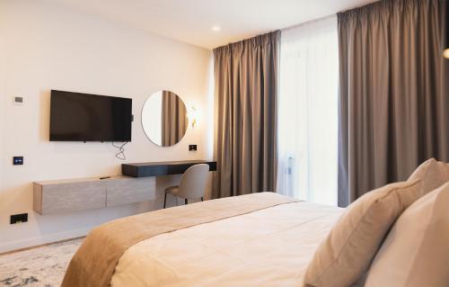 a hotel room with a bed and a flat screen tv at Electra Aparthotel in Rădăuţi