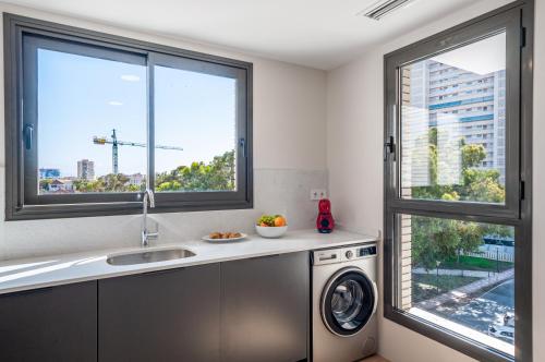 a kitchen with a washing machine and a window at Myflats Campello Beach in El Campello