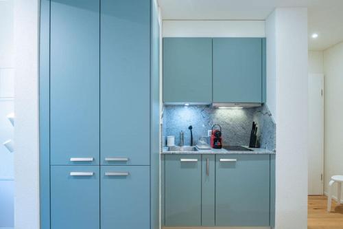 a kitchen with a blue refrigerator in a room at HITrental Riesbach Apartments in Zürich