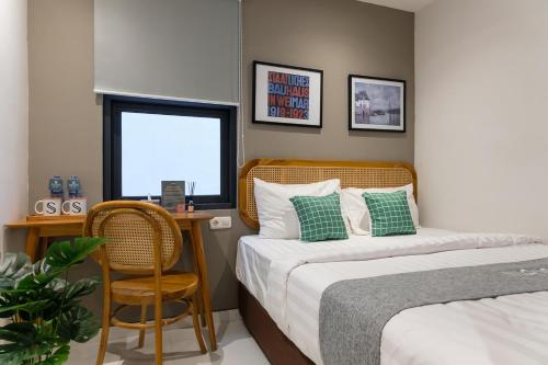 a bedroom with two beds and a table and a chair at Mono Coliving Pakis, Surabaya in Wonokitri 2