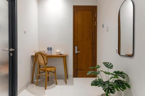 a hallway with a table and a chair and a door at Mono Coliving Pakis, Surabaya in Wonokitri 2