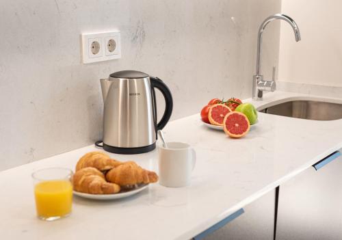 a breakfast of orange juice and croissants on a kitchen counter at Myflats Campello Beach in El Campello