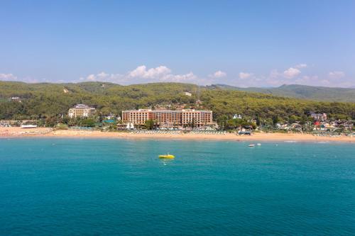 a yellow boat in the water next to a beach at AQI Pegasos Royal in Avsallar