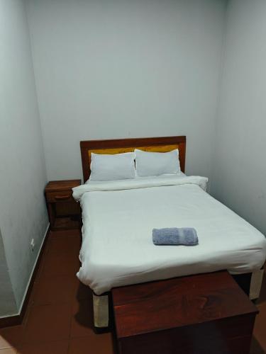 a white bed with a blue towel on it at Residencial Duma - Family Run Hotel in Vilanculos