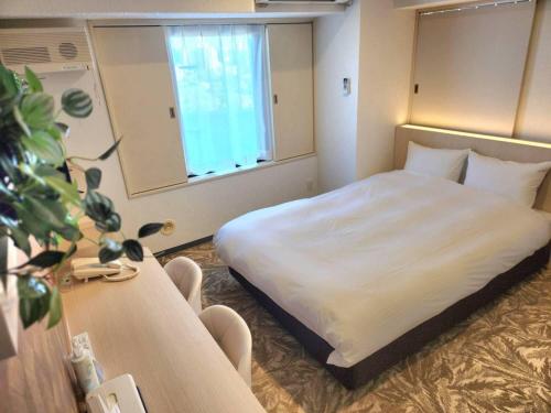 a hotel room with a bed and a window at Hotel Alpha Inn Akita in Akita