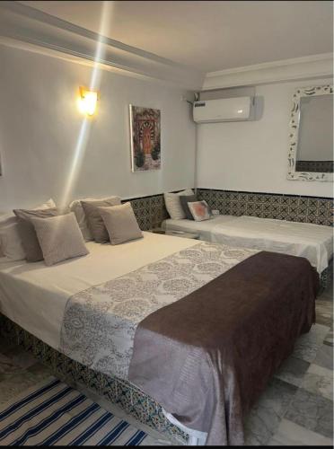 a hotel room with two beds and a couch at Charmante villa de 4 chambres au deux oueds hammamet in Nabeul