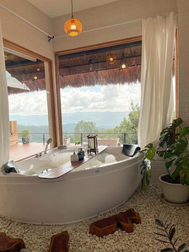 a bath tub in a bathroom with a large window at Gobgab Station room 2 in Ban Huai Khai