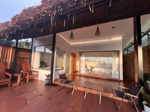 a living room with a wooden deck with a fireplace at Gobgab Station room 2 in Ban Huai Khai