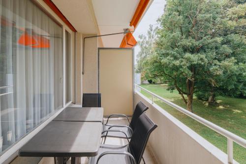 a table and chairs on a balcony with a window at Uze Apartments in Uzwil SG in Uzwil