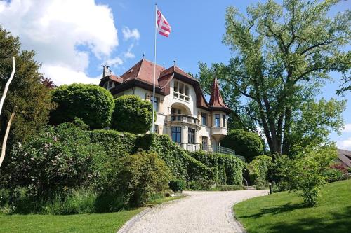 a house with a flag on top of a driveway at Villa unique, piscine et grand parc, Vorbourg 15 in Delémont